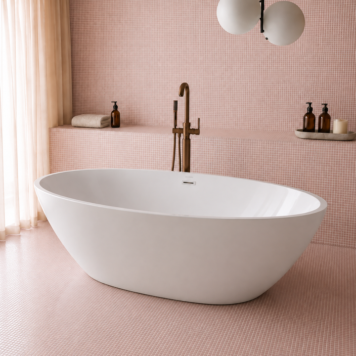 Bloemendaal 69 inch freestanding oval bathtub, angled view in a pink tiled bathroom with brass fixtures, Gramans Bathware